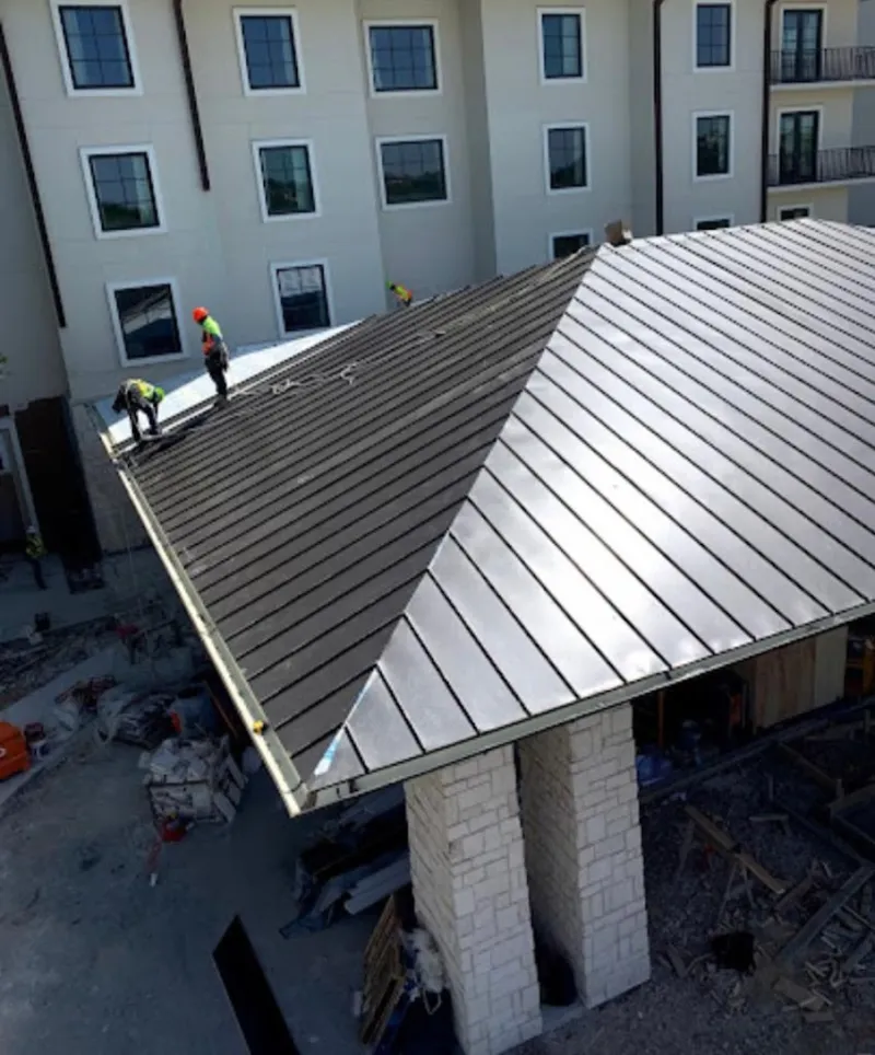 Crew installing standing seam metal roof panels on a commercial project in Chesapeake Beach